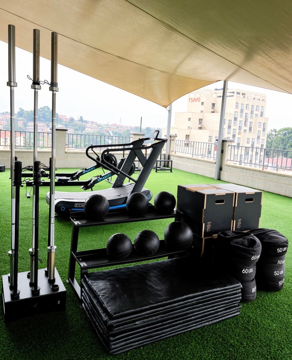 Barbells, slam balls, plyo boxes and sandbags under the canopy